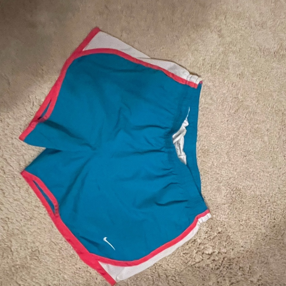 Bright blue/teal Nike shorts with pink trim.